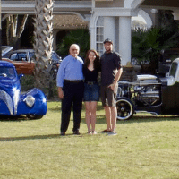 Father, Son, Daughter standing in front of some of the classic cars & hot rods, located at the FSD Hot Rod Ranch.