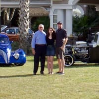 Father, Son, Daughter standing in front of some of the classic cars & hot rods, located at the FSD Hot Rod Ranch.